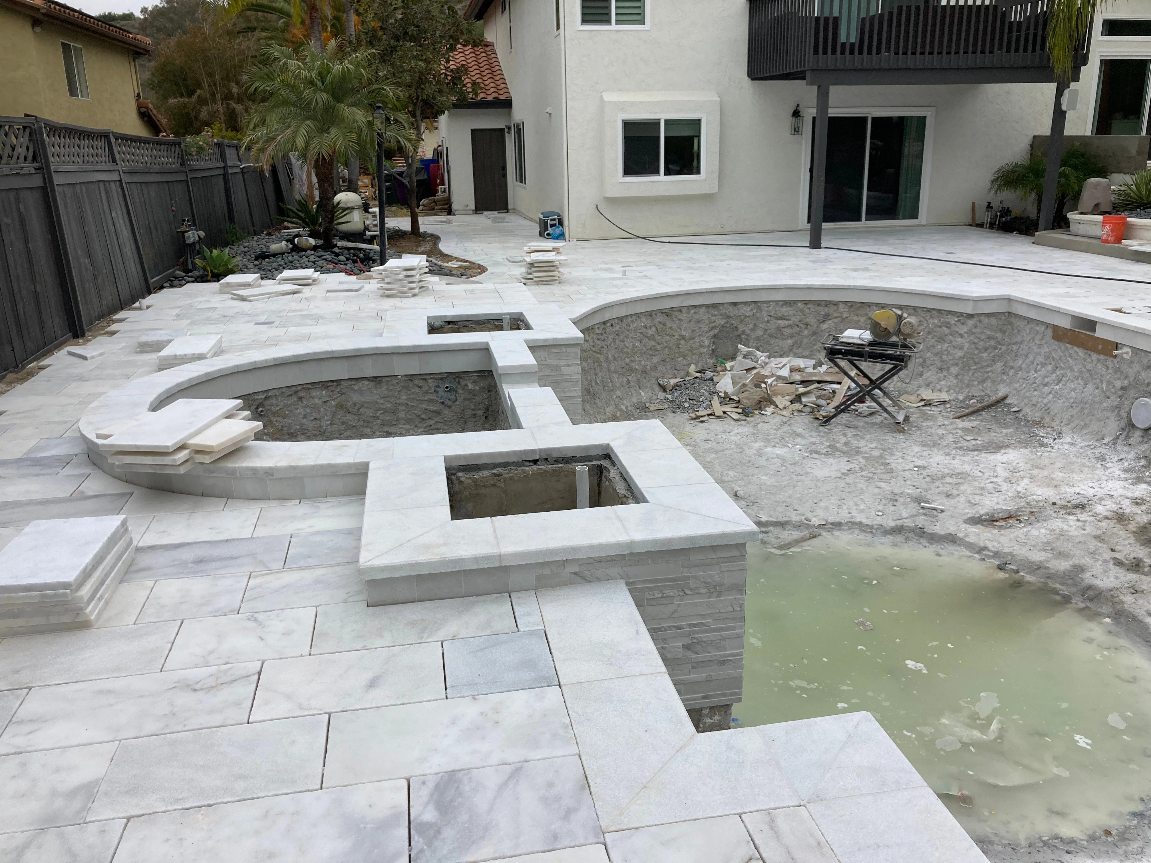 Poolside outdoor kitchen with stone finish and seating